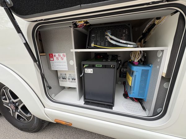 Open exterior storage compartment of a caravan showing different installation system.